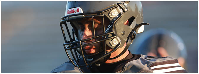 A football game is taking place on a field with players wearing blue and white uniforms. Description generated by AI