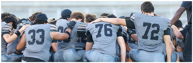 A group of football players on a field. Description generated by AI