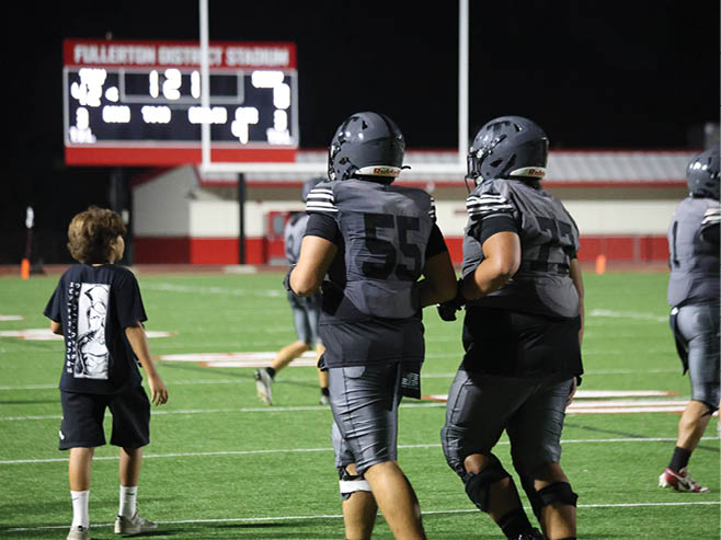 A group of football players in black and white uniforms are on the field. AI generated content