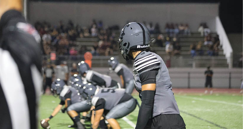 A group of people are kneeling on a field, possibly in a football game. AI generated content