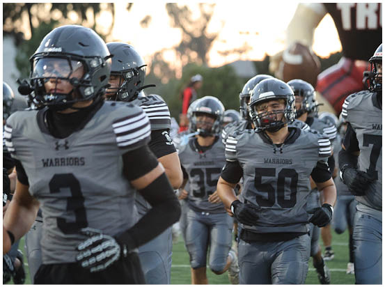 A football game is taking place on a field with players wearing blue and white uniforms. Description generated by AI