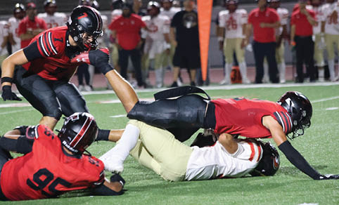 Two men wearing football uniforms are hugging each other on a field. AI generated content