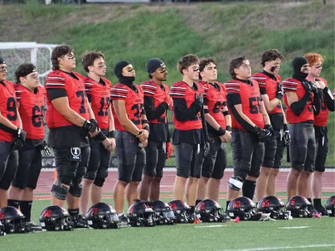 A group of football players in black and white uniforms are on the field. AI generated content