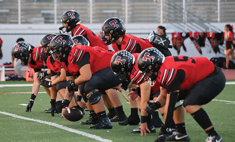 Two men wearing football uniforms are hugging each other on a field. AI generated content