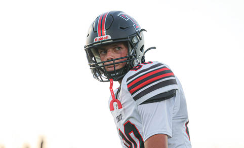 A man wearing a football helmet and face paint is smiling. AI generated content