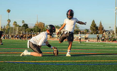 Two men wearing football uniforms are hugging each other on a field. AI generated content