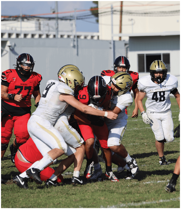 Three football players in blue and white uniforms running on a field. Description generated by AI