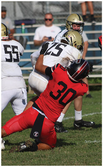 A football player catching a ball. Description generated by AI