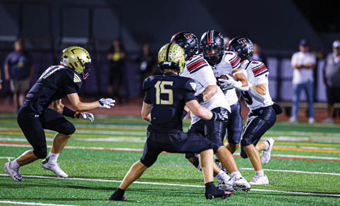 Two men wearing football uniforms are hugging each other on a field. AI generated content