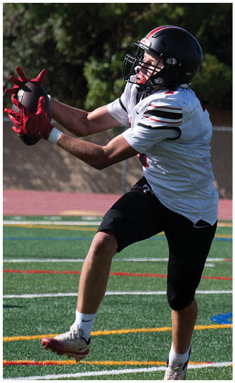 A football player catching a ball. Description generated by AI