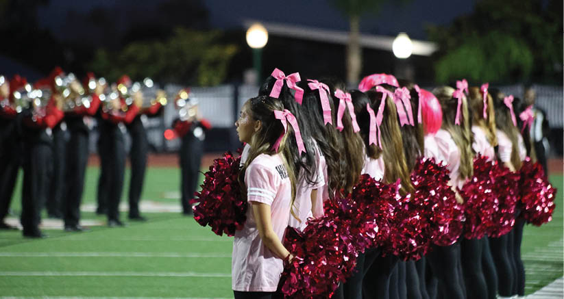 A group of people are kneeling on a field, possibly in a football game. AI generated content