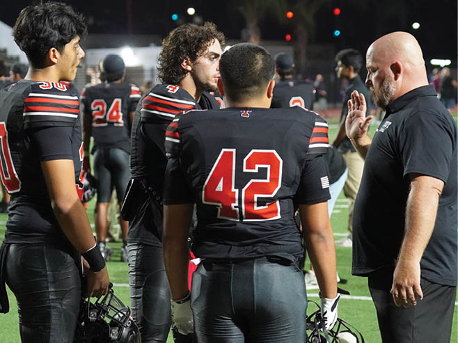 A group of football players in black and white uniforms are on the field. AI generated content