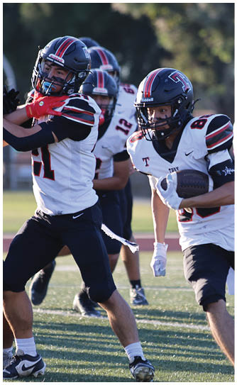 A football player catching a ball. Description generated by AI