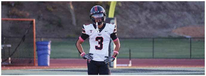 A football player wearing a blue and white uniform. Description generated by AI