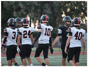 A group of football players on a field. Description generated by AI