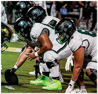 A football game is taking place with a group of men on the field. Description generated by AI