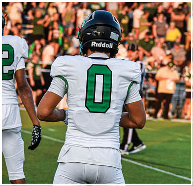 A football game is taking place with a group of men on the field. Description generated by AI