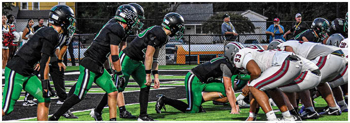 A group of football players on a field. Description generated by AI