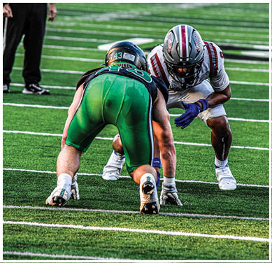 A football game is taking place with a group of men on the field. Description generated by AI
