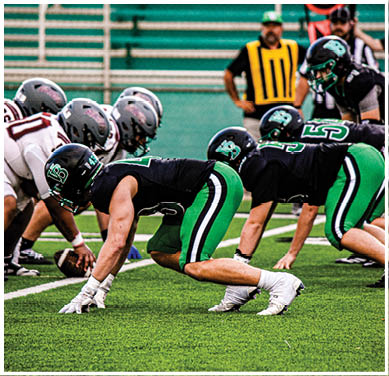 A football game is taking place with a group of men on the field. Description generated by AI