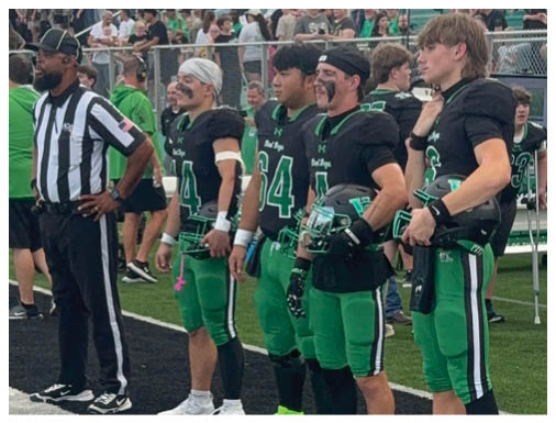 A football game is taking place with a group of men on the field. Description generated by AI