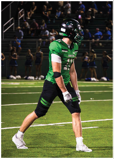 A football player wearing a blue and red jersey. Description generated by AI