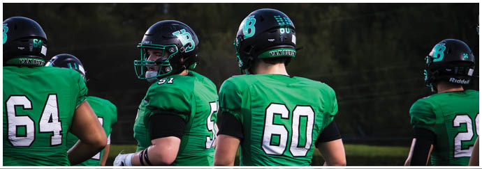 A group of football players on a field. Description generated by AI