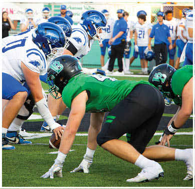A football game is taking place with a group of men on the field. Description generated by AI