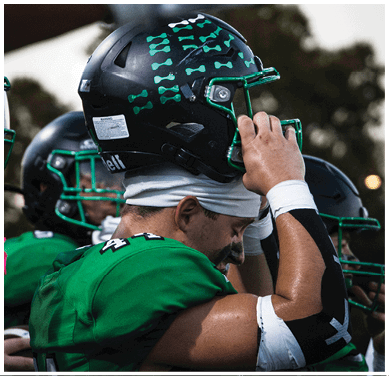 A football game is taking place with a group of men on the field. Description generated by AI
