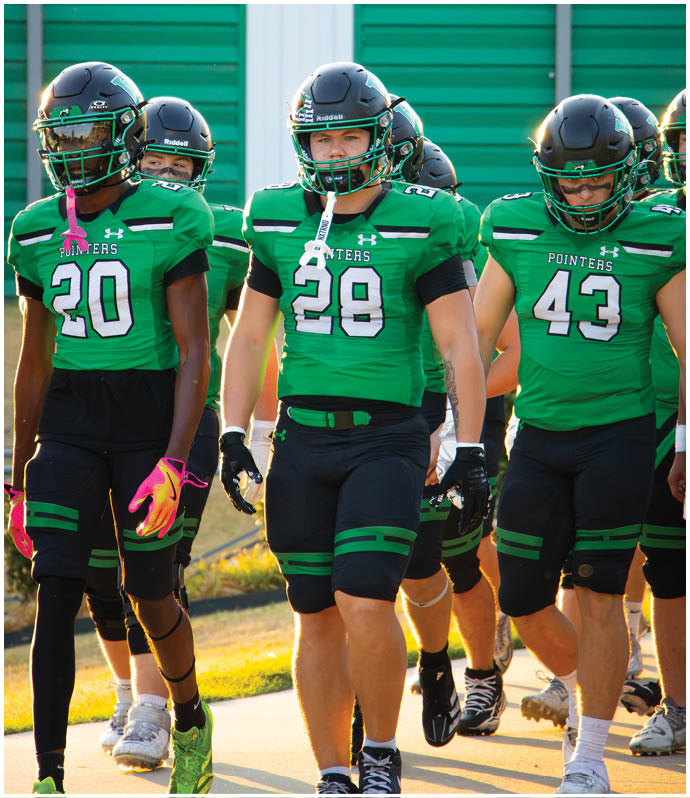 A group of football players wearing black and white uniforms. Description generated by AI