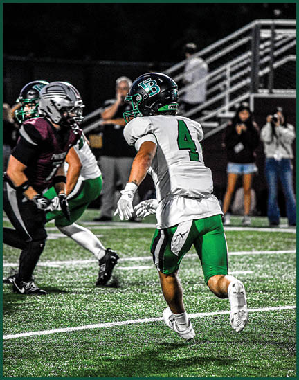 A football player running with a football. Description generated by AI