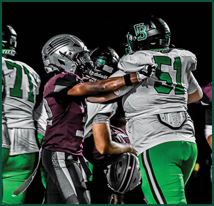 The football players are wearing black and white uniforms. Description generated by AI