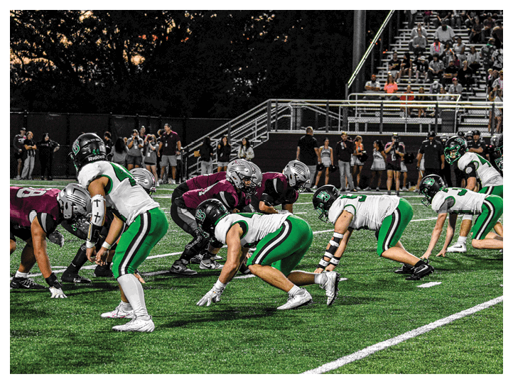 A group of football players on a field, one of them is running with a football. AI generated content