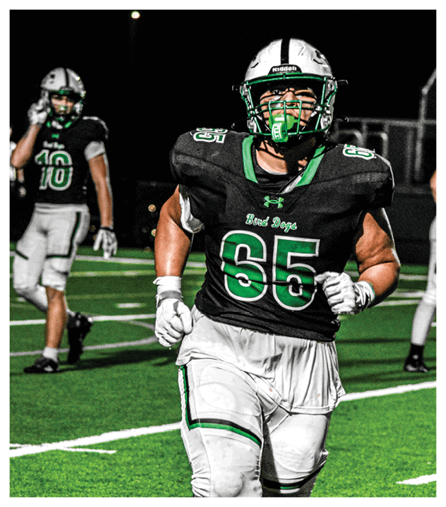 A football game is in progress with players on the field. One player is throwing a football while another player is trying to catch it. The players are wearing uniforms and are actively engaged in the game. AI generated content