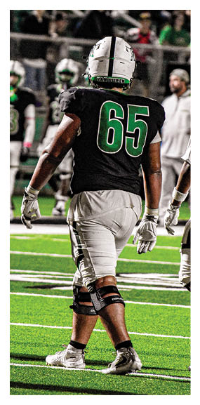 A man in a green shirt and black pants is preparing to throw a football. AI generated content