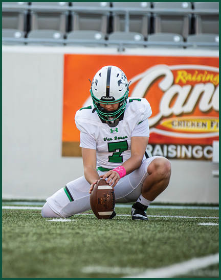 Three men wearing green and white uniforms are standing on a field. Description generated by AI
