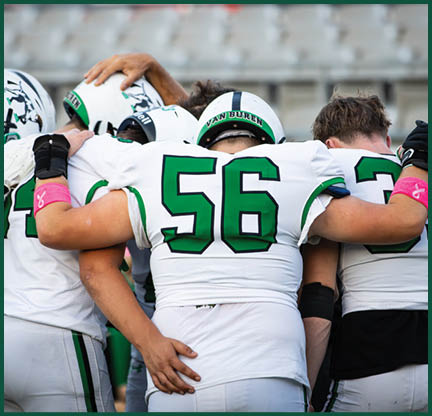 Two football players with black and white uniforms and black face paint. Description generated by AI