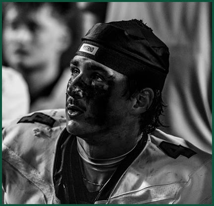 The football players are wearing black and white uniforms. Description generated by AI