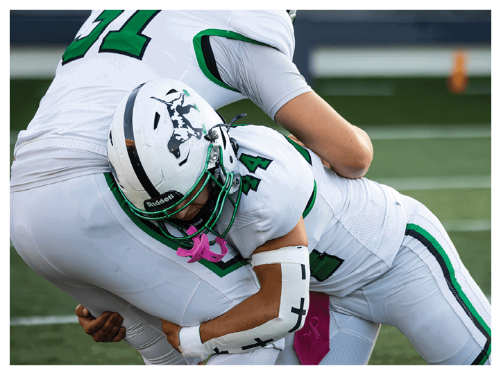 A group of football players on a field, one of them is running with a football. AI generated content