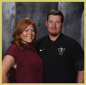 Five people wearing matching striped polo shirts and one person in a black shirt pose together against a dark, textured backdrop. Description generated by AI