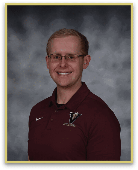 A person wearing glasses and a maroon polo shirt with a logo is smiling against a gray cloudy background. Description generated by AI