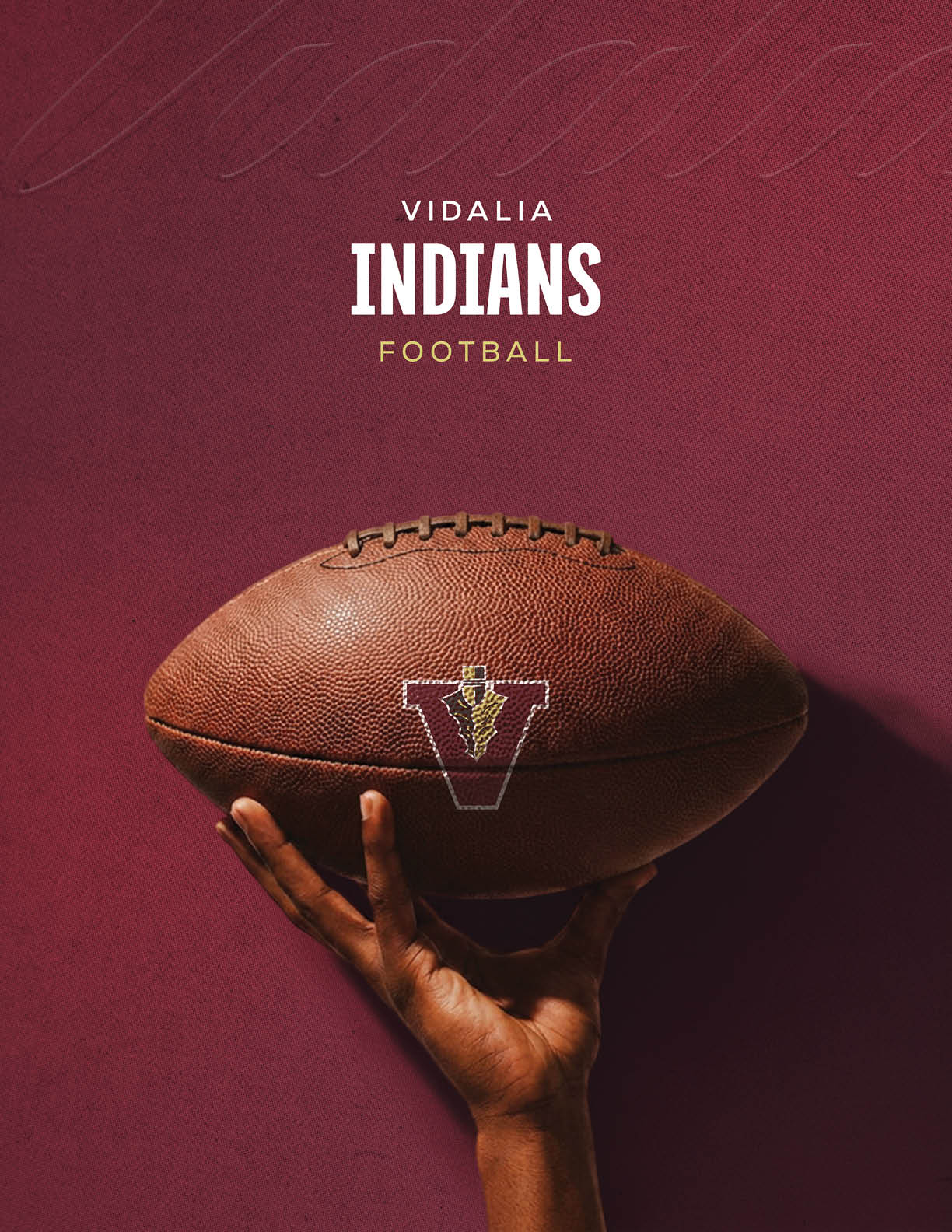 A hand is holding a football with a maroon background and the text Vidalia Indians Football above it. Description generated by AI