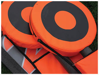 A person wearing a red football uniform with the number 90 and a white helmet with a red “W" stands with hands on hips among other similarly dressed players. Description generated by AI