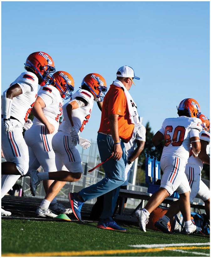 A group of football players wearing black and white uniforms. Description generated by AI