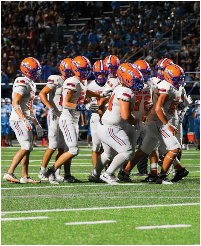 A group of football players wearing black and white uniforms. Description generated by AI