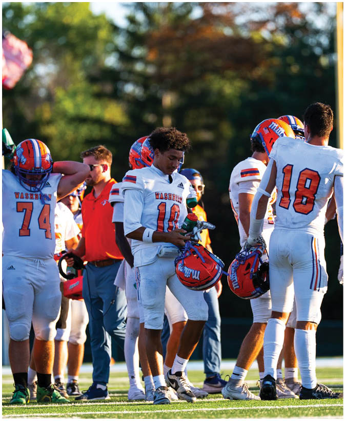 A group of football players wearing black and white uniforms. Description generated by AI