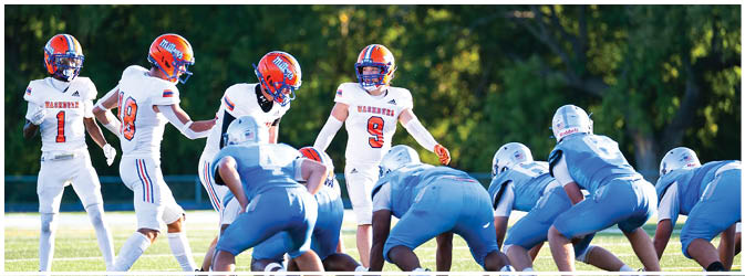 A group of football players on a field. Description generated by AI