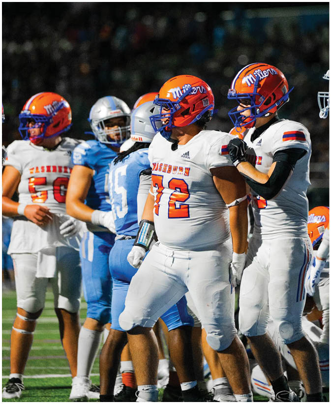 A group of football players wearing black and white uniforms. Description generated by AI