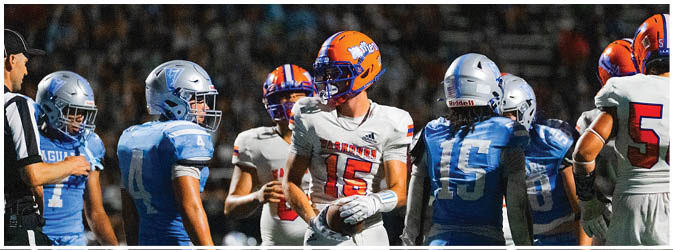 A group of football players on a field. Description generated by AI