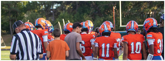 A group of football players on a field. Description generated by AI